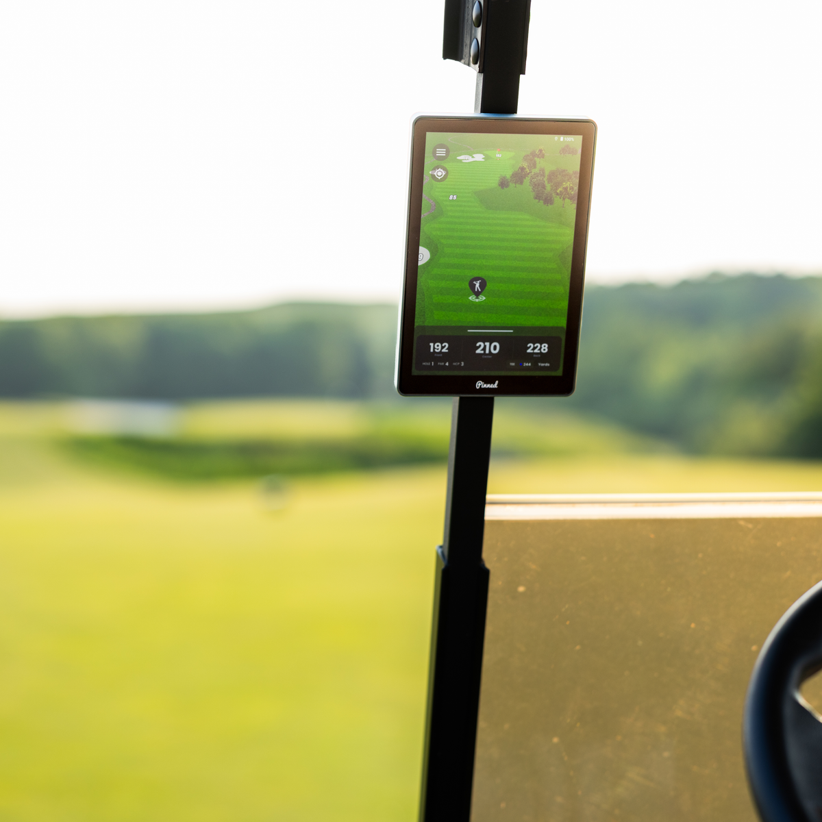 A Caddie GPS Smart Tablet magnetically attached to a golf cart on a golf course
