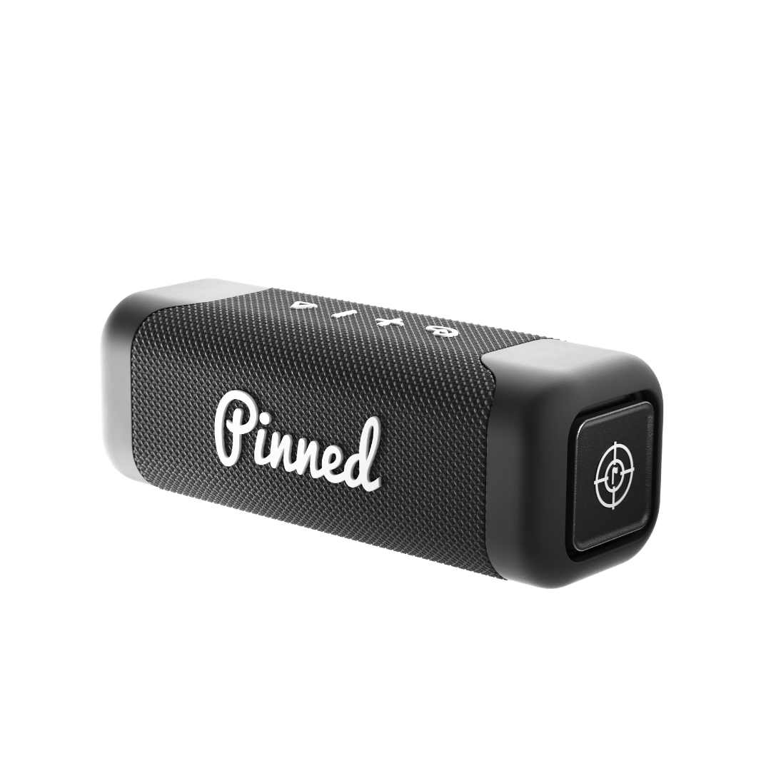 Black portable speaker with 'Pinned' branding in white on a white background