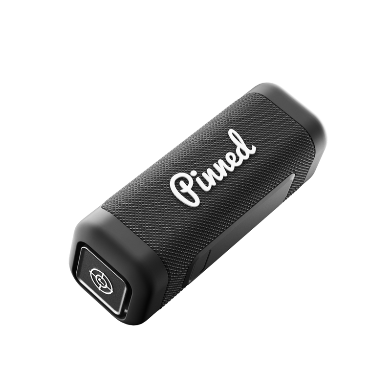Black portable speaker with 'Pinned' branding in white on a white background