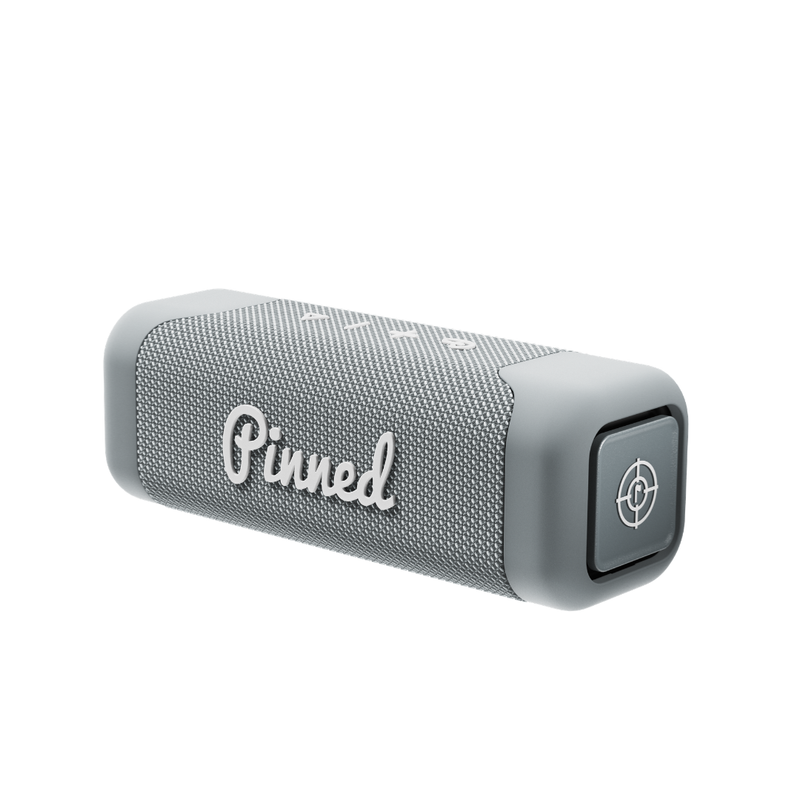 Gray portable speaker with 'Pinned' branding in white on a white background