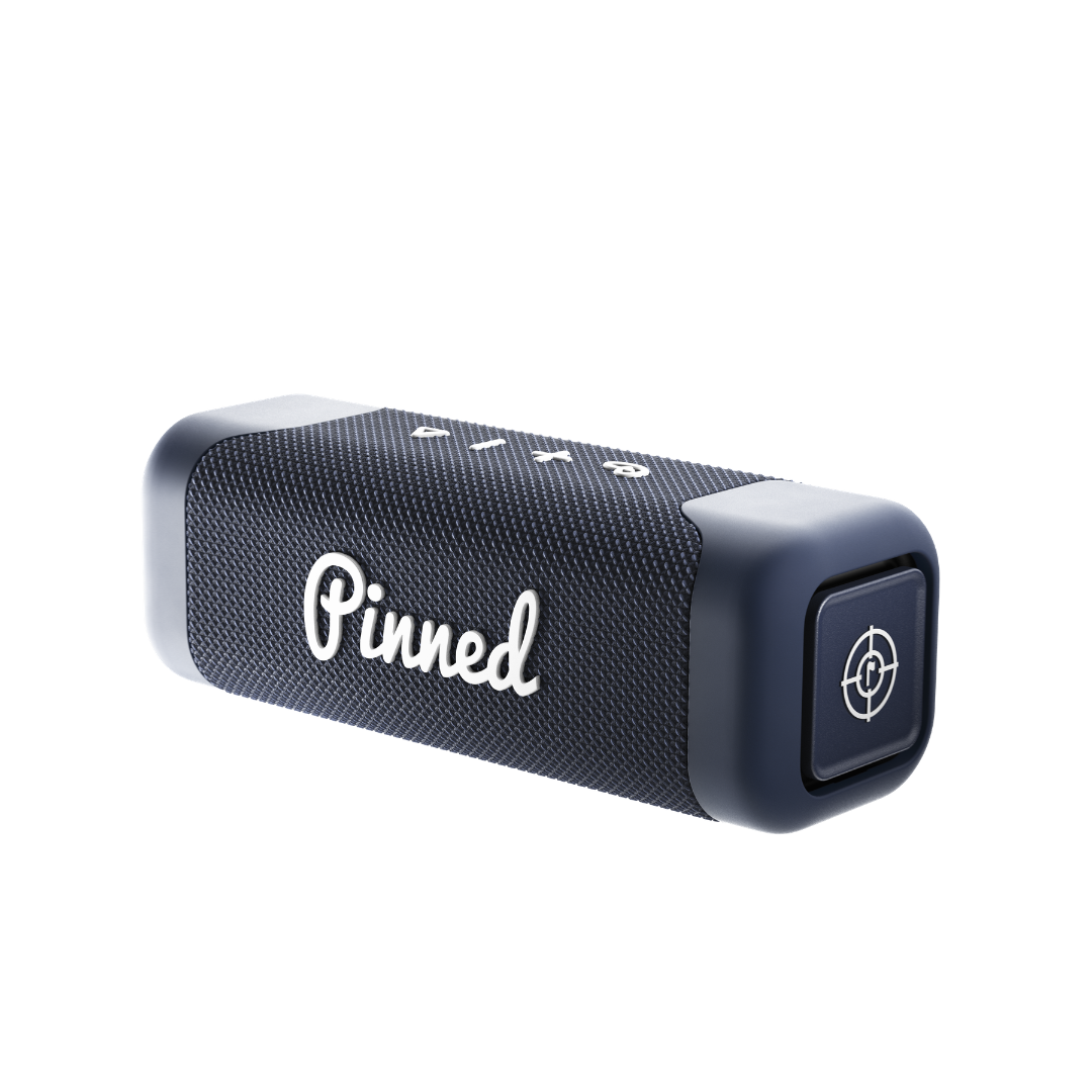 Navy blue portable speaker with 'Pinned' branding in white on a white background