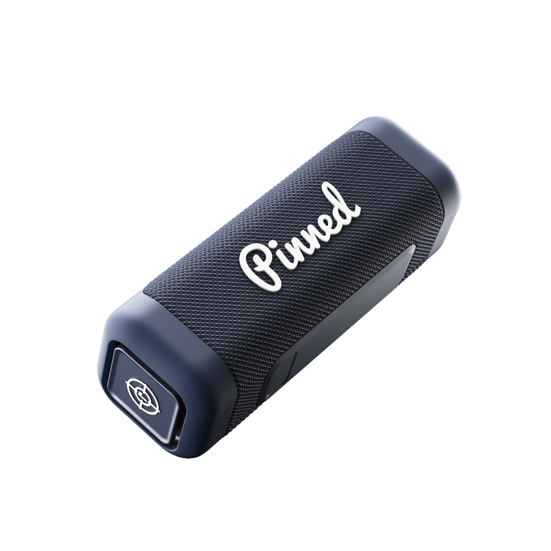 Navy blue portable speaker with 'Pinned' branding in white on a white background