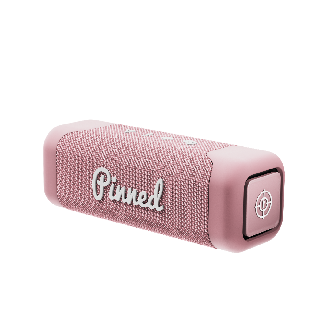 Pink portable speaker with 'Pinned' branding in white on a white background