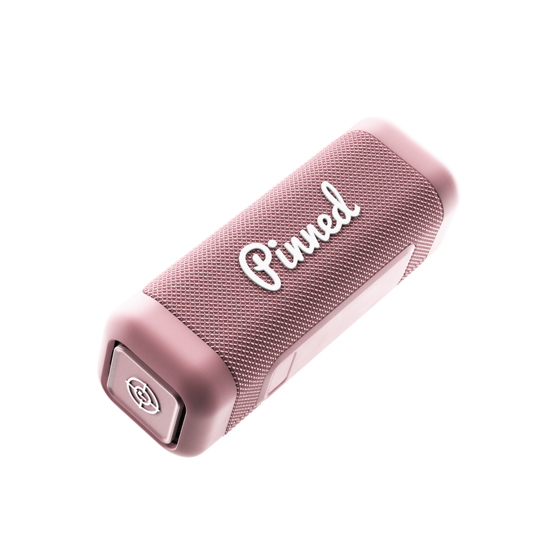 Pink portable speaker with 'Pinned' branding in white on a white background