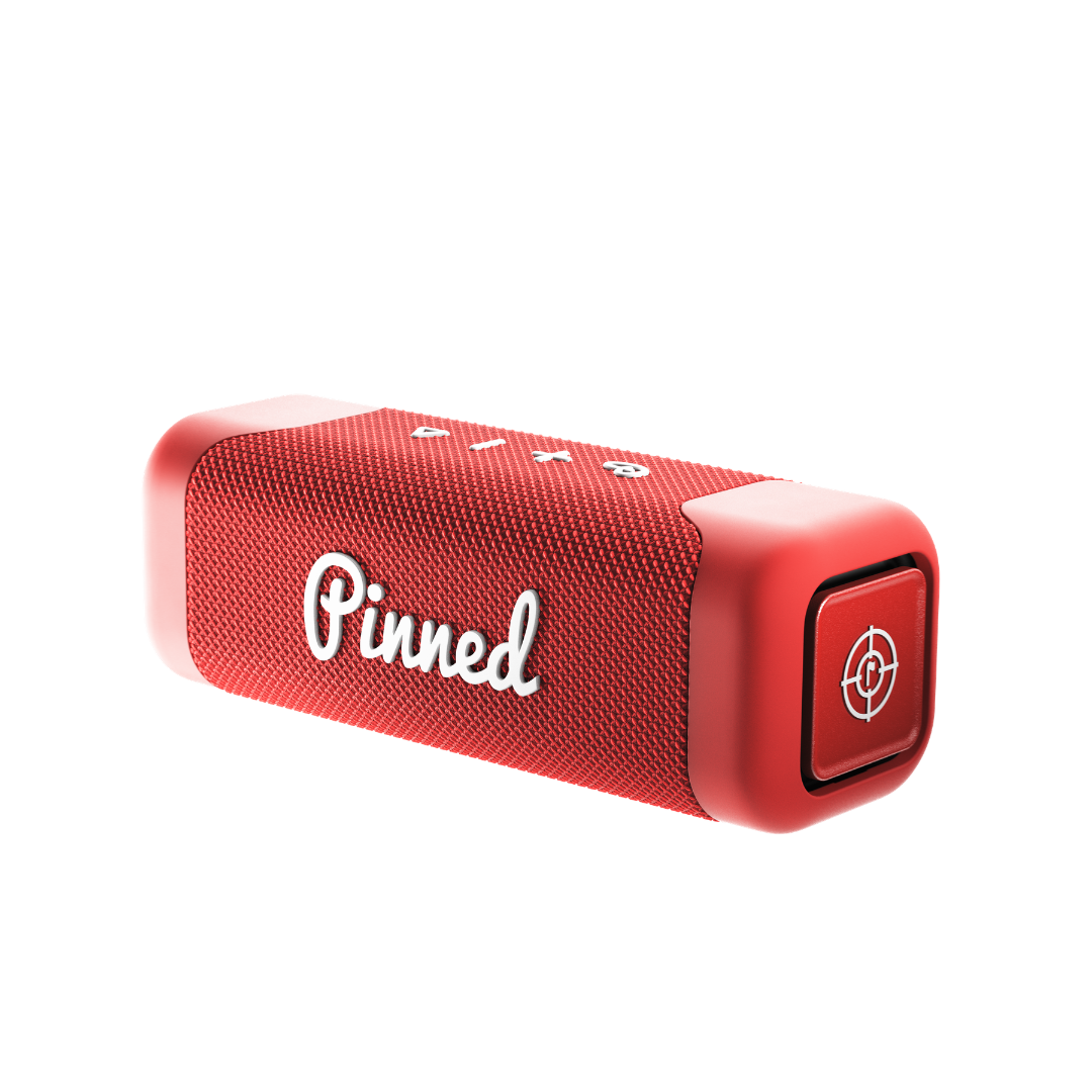 Red portable speaker with 'Pinned' branding in white on a white background